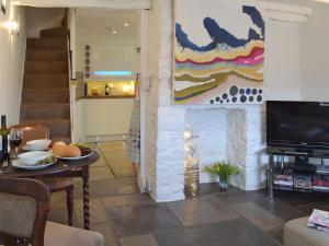 a living room with a table and a painting on the wall at Samphire Cottage in Brixham