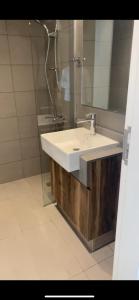 ein Badezimmer mit einem weißen Waschbecken und einem Spiegel in der Unterkunft شقة في الممشى الشارقة in Schardscha