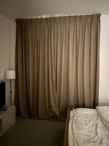 ein Schlafzimmer mit einem Bett und einem Vorhang in der Unterkunft شقة في الممشى الشارقة in Schardscha