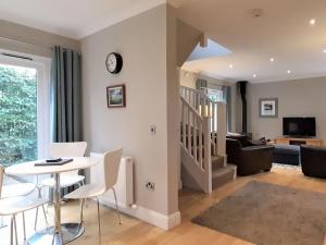 a living room with a table and chairs and a couch at Acorn Cottage in Kippen