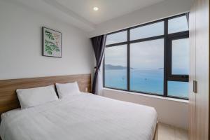 a bedroom with a bed and a large window at MySea Nha Trang Apartments in Nha Trang