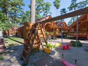 a playground with swings and a tree at Holiday houses near the seaside beach, Pobierowo in Pobierowo