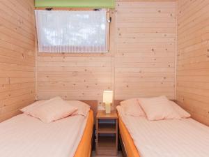 a bedroom with two beds and a table with a lamp at Holiday houses near the seaside beach, Pobierowo in Pobierowo