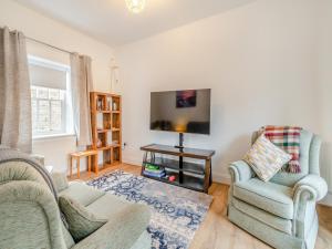 a living room with two chairs and a flat screen tv at The Old Workhouse in Great Driffield