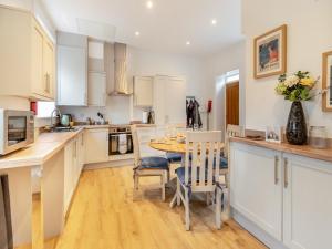 a kitchen with white cabinets and a table and chairs at The Old Workhouse in Great Driffield