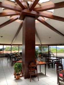 un restaurant avec des tables, des chaises et des fenêtres dans l'établissement Hotel Colinas Altavista, à Tarbaca