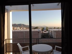 Habitación con vistas a un balcón con mesa y sillas. en DEPARTAMENTOS LEMOS en Mendoza