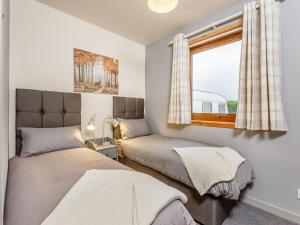 a bedroom with two beds and a window at Church Court Cottage - Uk39009 in Halkirk