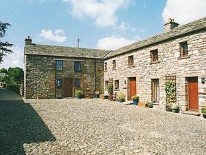 a large stone building with a cobblestone driveway at Mill Moor - B6064 in Pooley Bridge