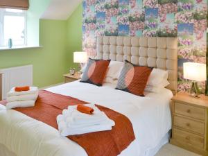 a bedroom with a large bed with towels on it at Hazelnut Cottage in Sharperton
