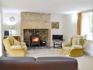 a living room with a couch and a fireplace at Hazelnut Cottage in Sharperton