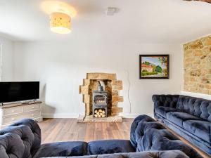 sala de estar con sofá y chimenea en Castle Cottage, en Castleton