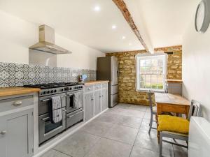 a kitchen with stainless steel appliances and a table at Castle Cottage in Castleton