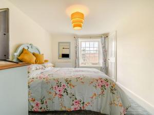 a bedroom with a bed with a floral bedspread at Castle Cottage in Castleton