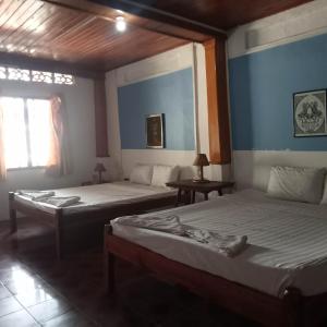 a bedroom with two beds and a window at Nomad Guesthouse in Kratie