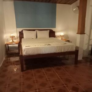Ce lit se trouve dans un dortoir doté de 2 lampes sur les tables. dans l'établissement Nomad Guesthouse, à Kratie
