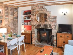 ein Wohnzimmer mit einem gemauerten Kamin und einem Tisch in der Unterkunft Mouse House in Hastings