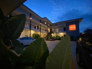 a building with a car parked in a parking lot at Red Heritage Hotel in Ban Mon