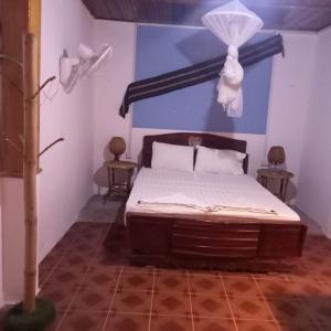1 dormitorio con 1 cama con pared azul en Nomad Guesthouse, en Kratié