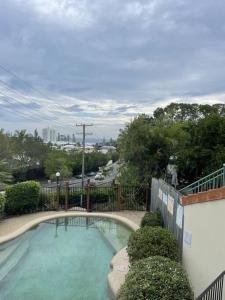 a swimming pool in front of a fence at Ocean view apartment! 300m to beach. Pet friendly. in Alexandra Headland