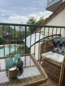 balcón con mesa y silla con mesa de cristal en Ocean view apartment! 300m to beach. Pet friendly., en Alexandra Headland