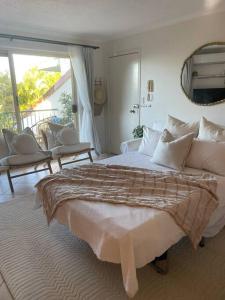 1 dormitorio con 1 cama grande y balcón en Ocean view apartment! 300m to beach. Pet friendly., en Alexandra Headland