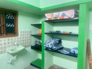 une étagère verte dans une salle de bains avec lavabo dans l'établissement Castle50 - Green Villa homestay, à Coimbatore