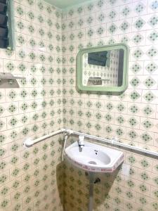 La salle de bains est pourvue d'un lavabo et d'un miroir. dans l'établissement Castle50 - Green Villa homestay, à Coimbatore