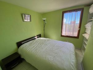 um quarto verde com uma cama e uma janela em Villa Port Leucate, 3 pièces, 6 personnes - FR-1-81-582 em Port Leucate