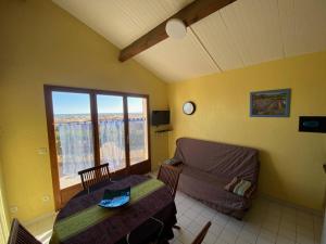 uma sala de estar com um sofá, uma mesa e uma janela em Villa Port Leucate, 3 pièces, 6 personnes - FR-1-81-582 em Port Leucate