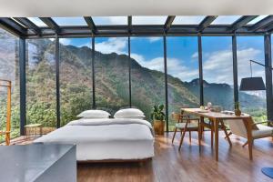 een slaapkamer met een bed en uitzicht op de bergen bij Purespace in Zhangjiajie