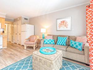 uma sala de estar com um sofá e uma mesa em Beach Racquet A126 em Tybee Island