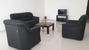 sala de estar con 2 sillas y mesa de centro en Rodrigo Apartments, en Boralesgamuwa