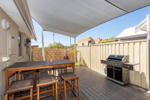 a patio with a table and chairs and a grill at 4Shore with Wifi in Wonnerup