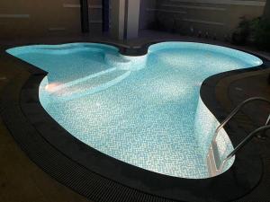 Una gran piscina con luz en un edificio. en Tycoon suite pattaya, en Pattaya central 47 fotos más