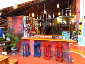 a bar with red and blue stools in a restaurant at Casona Don Juan Hostel in San Gil +151 photos