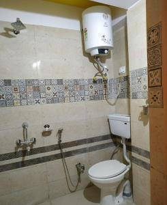 a bathroom with a toilet and a light on the wall at Rambler's Nesting Homestay in Darjeeling