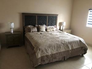 ein Schlafzimmer mit einem großen Bett und zwei Nachttischen in der Unterkunft Casa col mexicali in Rosarito