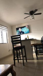 ein Esszimmer mit einem Tisch und Stühlen sowie einem Flachbild-TV in der Unterkunft Casa col mexicali in Rosarito