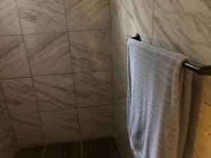 eine Dusche mit einem weißen Handtuch an der Wand in der Unterkunft Casa col mexicali in Rosarito