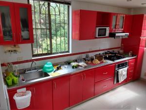 eine rote Küche mit roten Schränken und einem Waschbecken in der Unterkunft paraiso in Fusagasuga