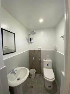 a white bathroom with a sink and a toilet at Villa Kendra in Moalboal +55 photos
