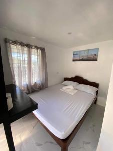 Villa Kendra في موالبوال: غرفة نوم مع سرير أبيض كبير ومكتب أسود
