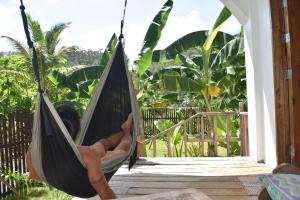 a person laying in a hammock on a porch at Pacifico Surf Bayay 