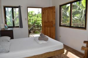 1 dormitorio con 1 cama, 2 ventanas y puerta en Pacifico Surf Bayay, 