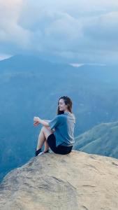 a woman sitting on top of a mountain at Onestar Ella in Ella
