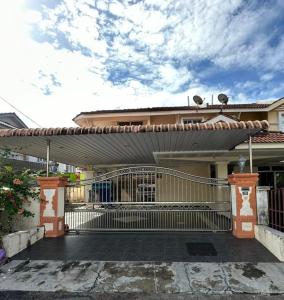 une terrasse couverte d'une maison avec une porte métallique dans l'établissement Awani Homestay, à Permatang Janggus