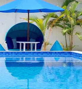 a table with an umbrella next to a swimming pool at Cosè Gili Beach Resort in Gili Trawangan