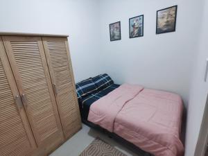 a small bedroom with a bed and a cabinet at Field Residences Bldg5 in Manila