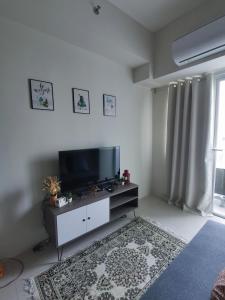 uma sala de estar com uma televisão de ecrã plano e um tapete em Field Residences Bldg5 em Manila